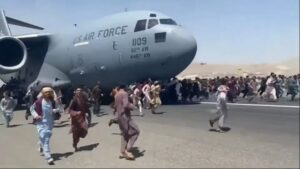 افغان يتشبثون بطائرة امريكية اثناء اقلاعها من مطار كابول(CNN)