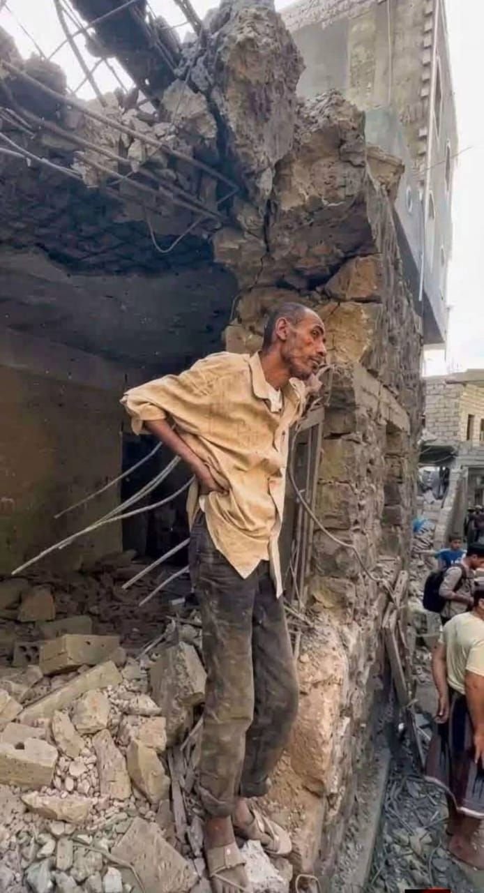 رجل يقف أمام بيته المهدم