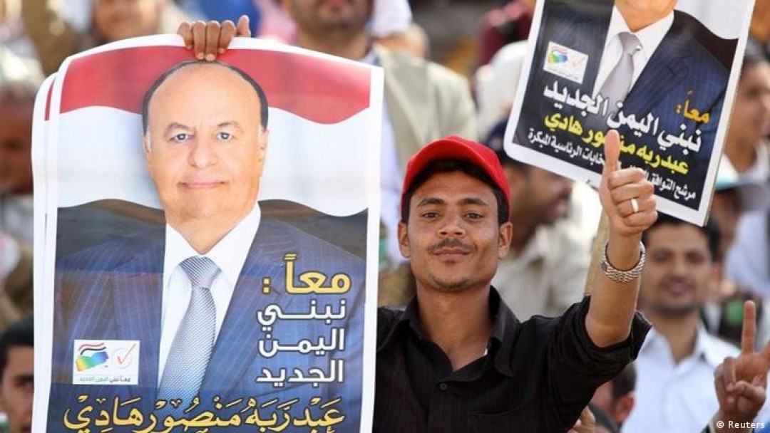 شاب يرفع صورة عبدربه منصور شاب يرفع صورة عبدربه منصور